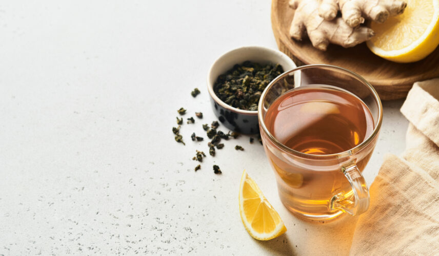 Ginger tea. Cup of ginger tea with lemon, honey and mint on grey background. Concept alternative medicine, natural homemade remedy for cold and flu. Top view. Free space for your text.