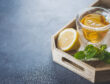 Medicines and Health Healthcare Concept. Cup of hot tea with lemons, pills and thermometer on wooden tray on concrete table background